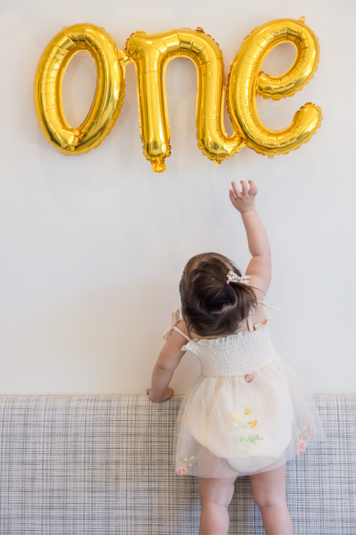 adorable photo of baby standing up to reach for the 