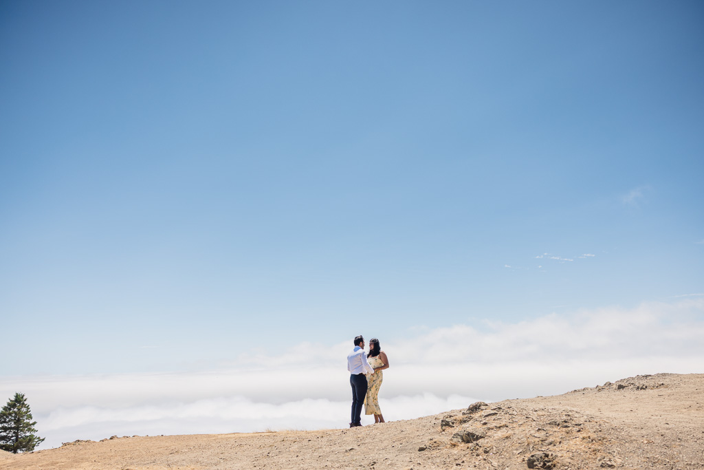 engagement photos against layers of clouds in the sky