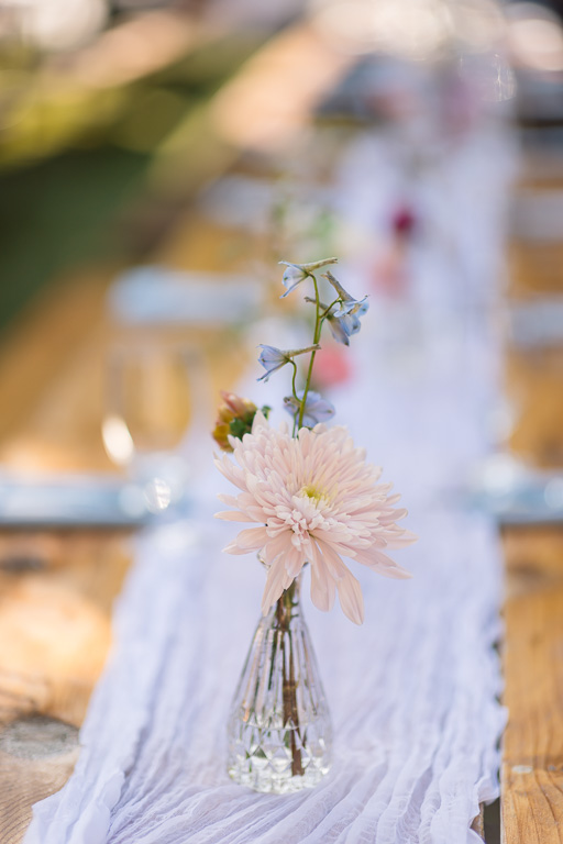 salmon colored reception table centerpiece on white table runner