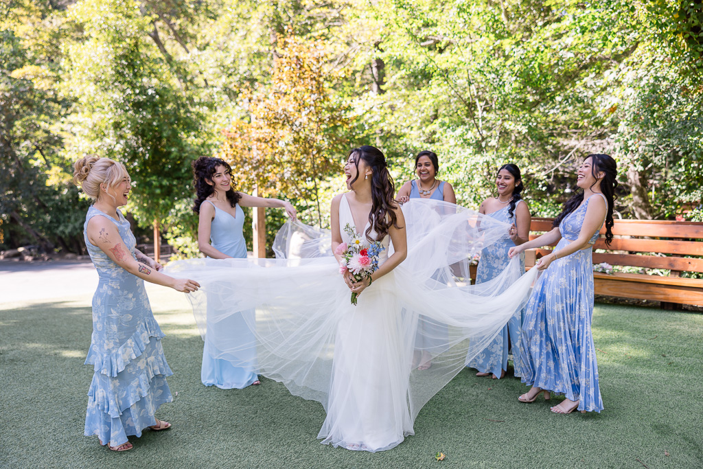 bridesmaids playing with the bride's dress