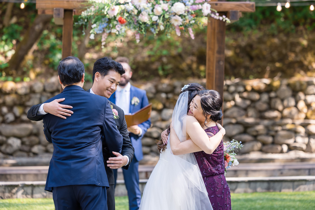 hugs between the bride, groom, and her parents