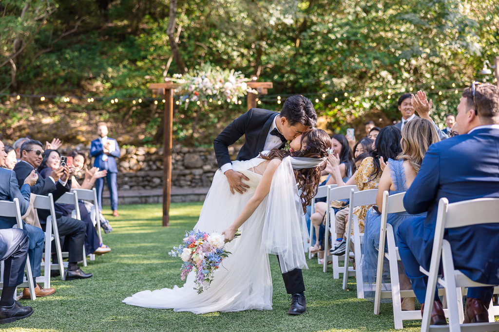 dip and kiss at the end of the wedding aisle