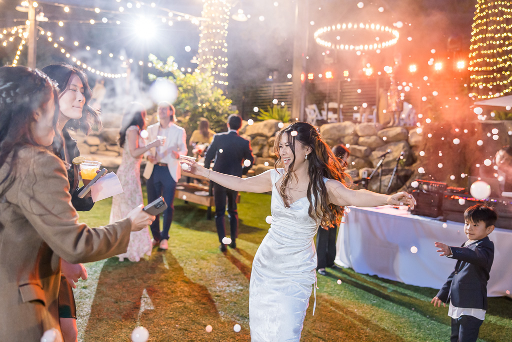 bride dancing joyfully with fog bubbles around her