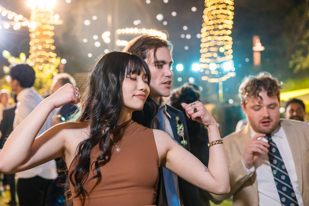 guests dancing under colorful DJ lights