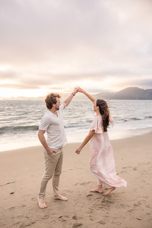 a playful twirl on the beach for maternity photos