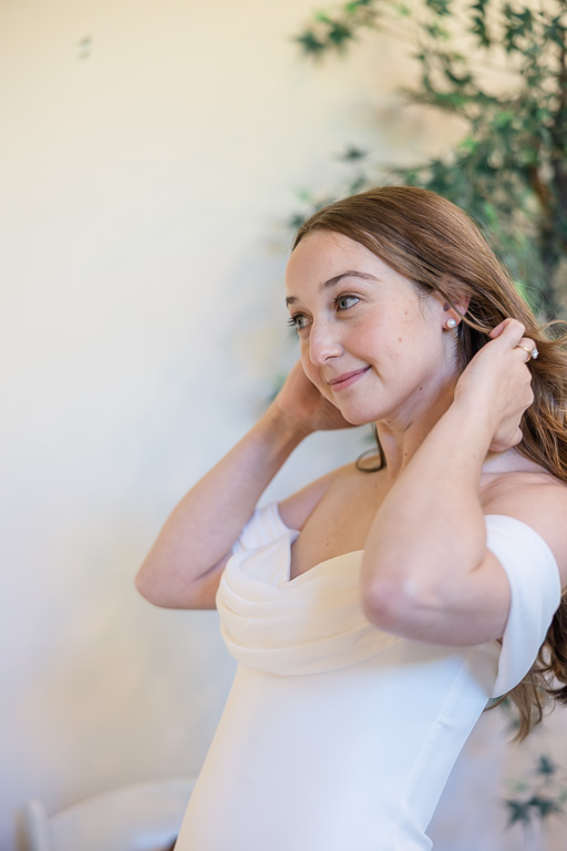 bride fixing up her hair before wedding
