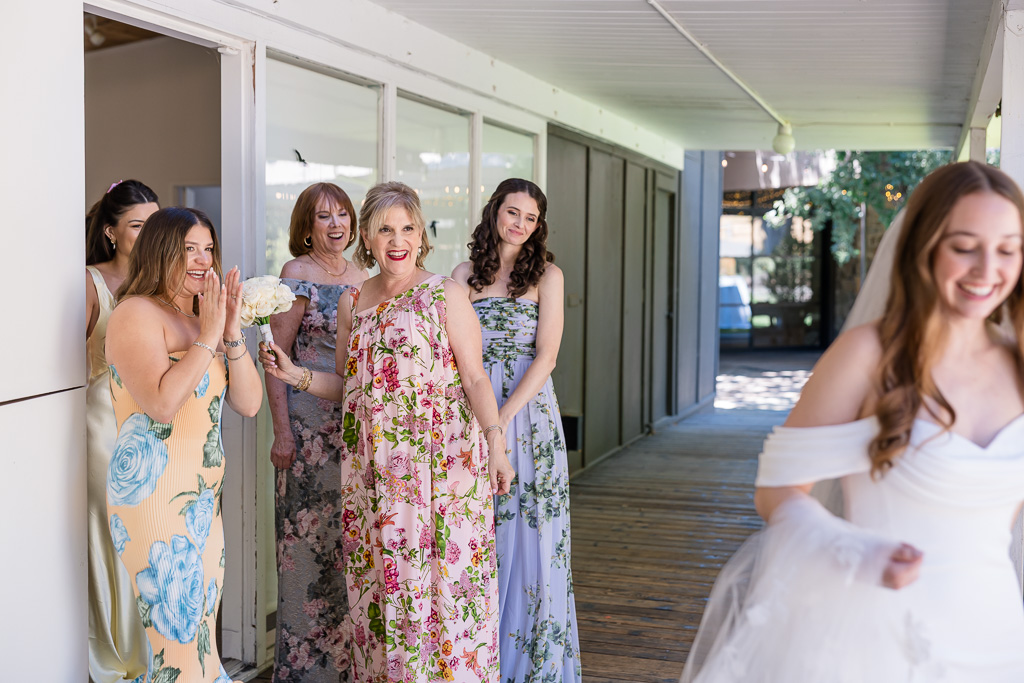 candid moment of mom and ladies admiring the bride from behind