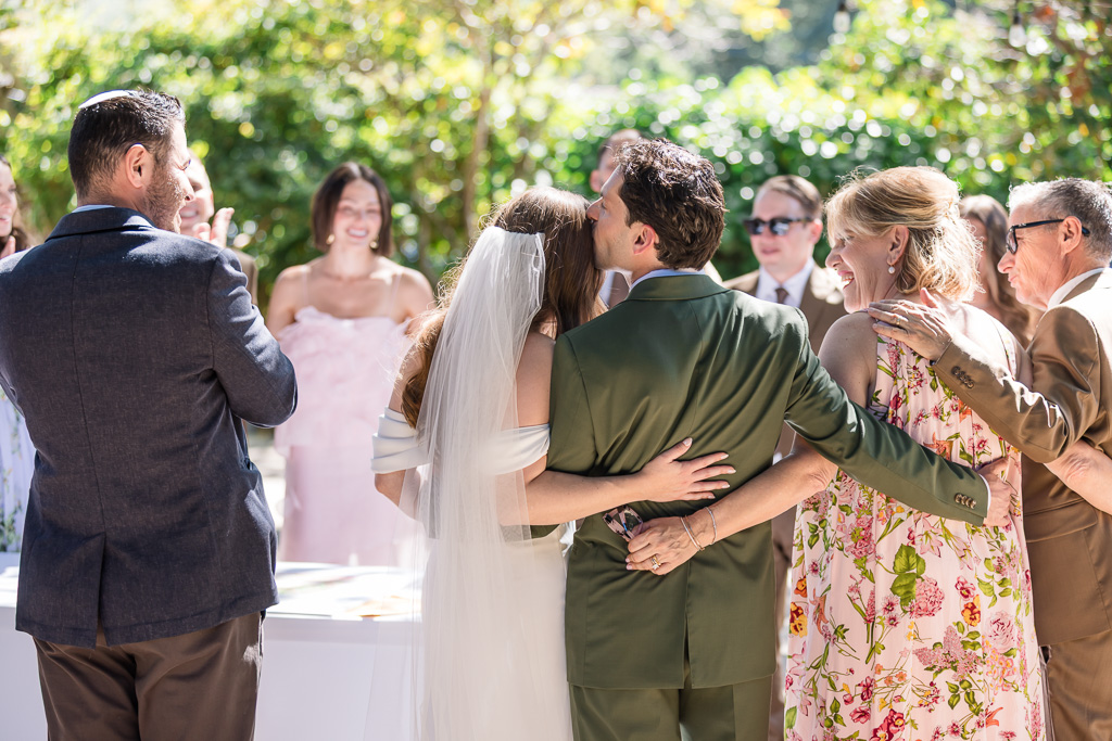 groom giving bride a kiss during ketubah ceremony