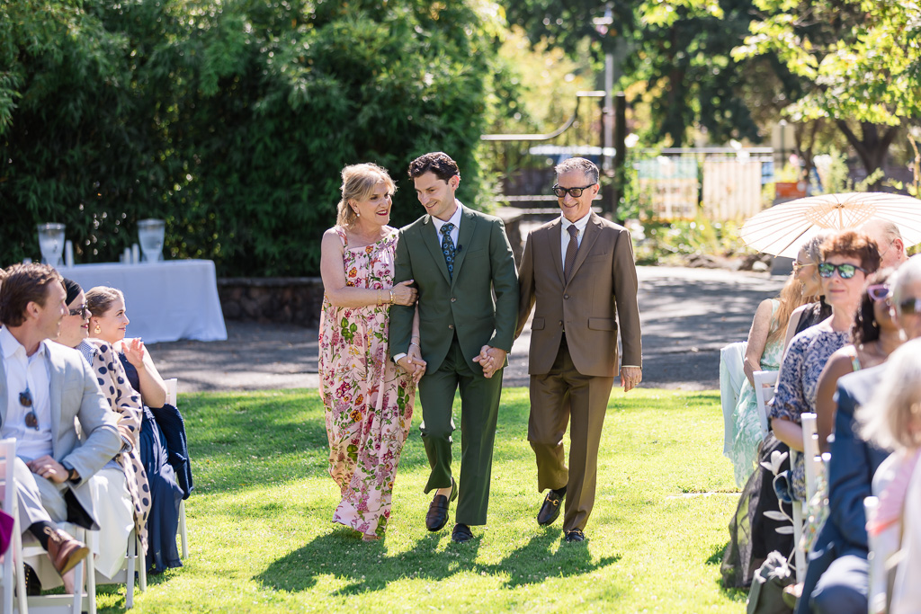 groom's parents walking him up the aisle