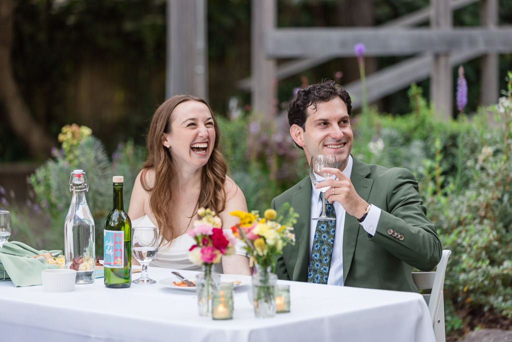 bride and groom laughing at the dinner speeches