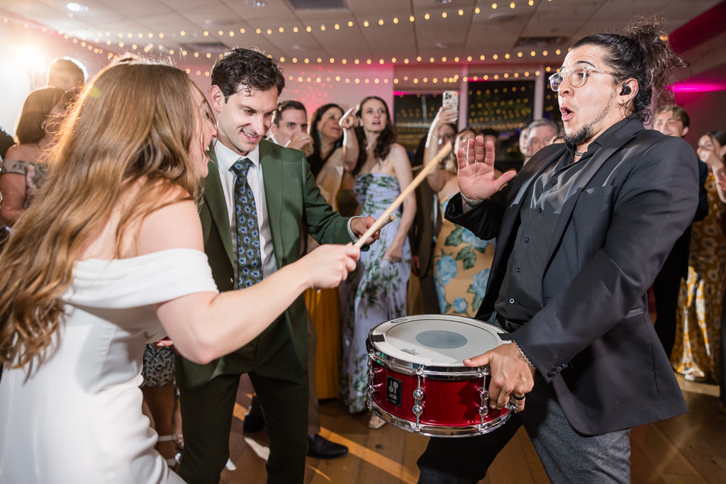 bride hitting the drummer's drum while everyone dances around them