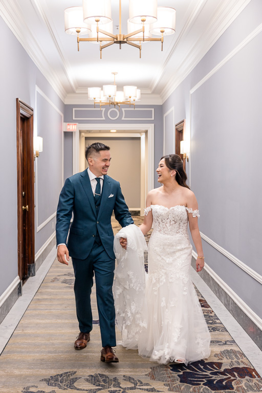 candid moment between bride and groom as they walk down the hallway of the Palace Hotel