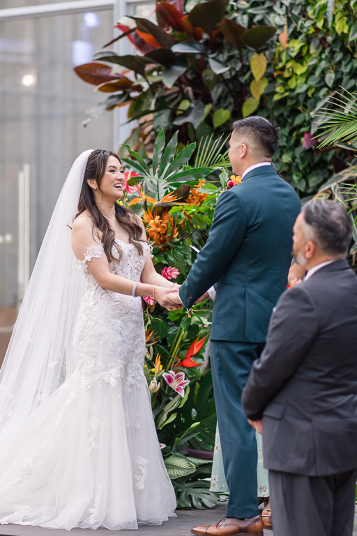 bride and groom standing at the living wall for their ceremony