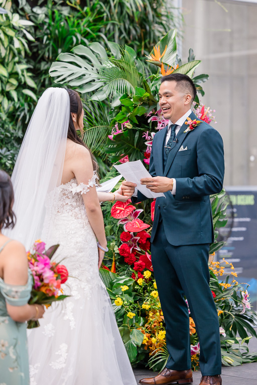groom reading his wedding vows in front of living wall decoration