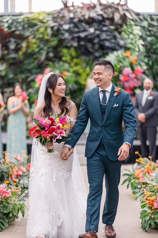 newlyweds walking back down the aisle after ceremony ended at the Cal Academy
