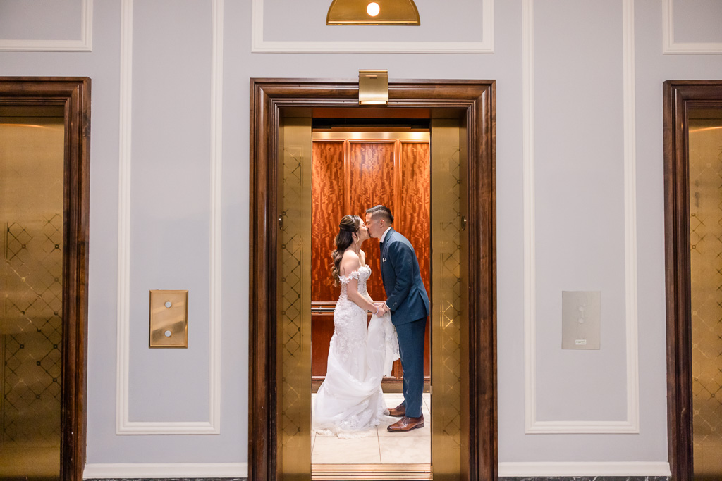 bride and groom kissing in the elevator car of the Palace Hotel as the doors slide closed