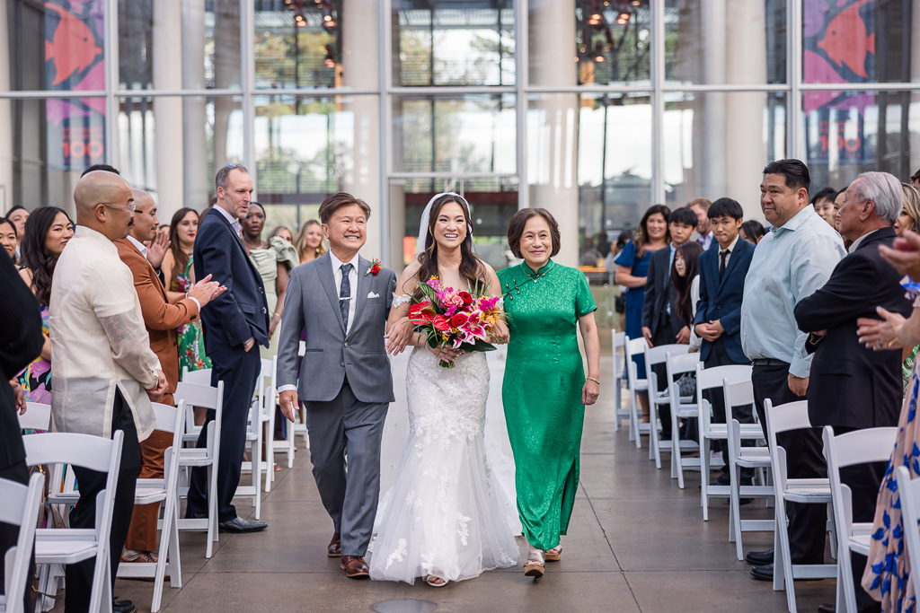 bride and her parents walking down the aisle