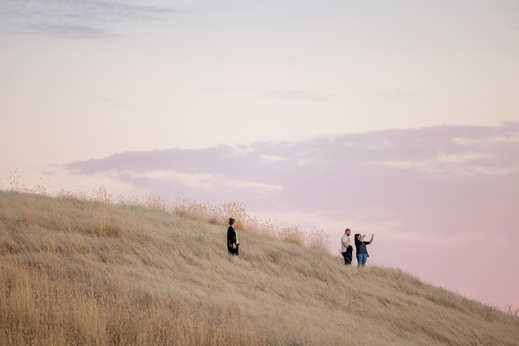 candid shot of newly engaged girl taking photo of new ring