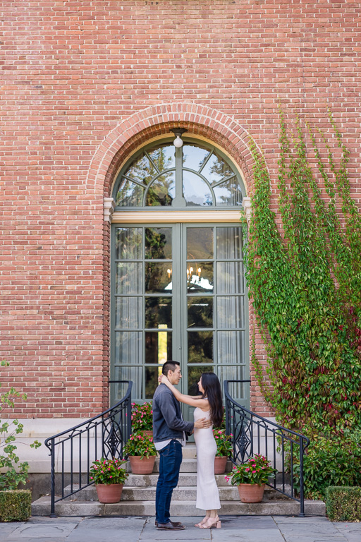 standing in front of brick house about to propose