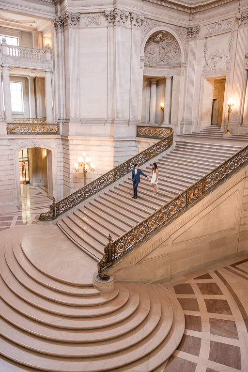 faraway angle of couple walking down SF City Hall's grand staircase
