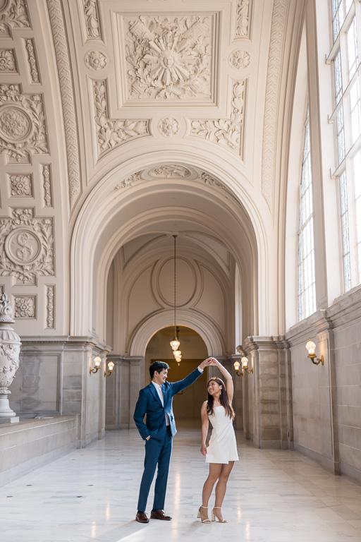 couple dancing on the fourth floor of San Francisco City Hall showing the arches and architecture
