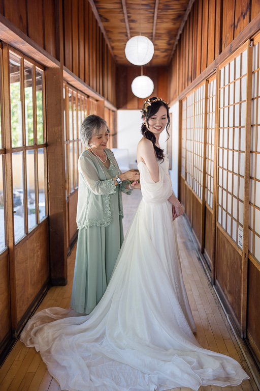 mom helping bride with dress