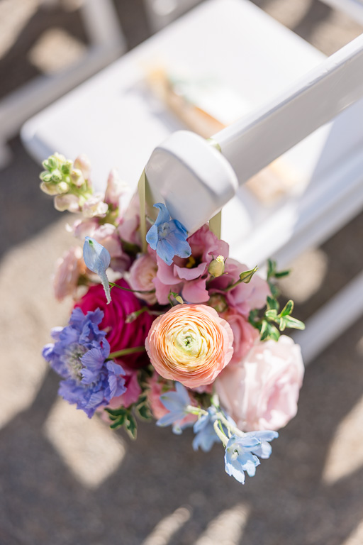 close-up shot of floral decor on ceremony chairs