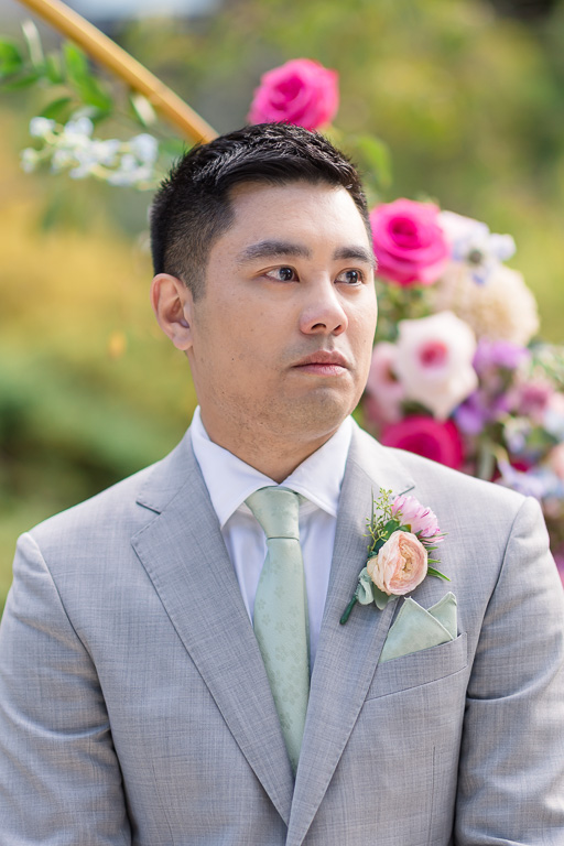 tearful groom looking down the aisle at his bride