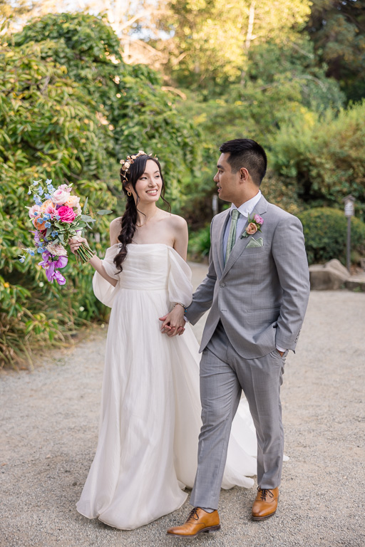 bride and groom walking through garden