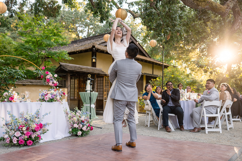 groom lifting up the bride during the first dance