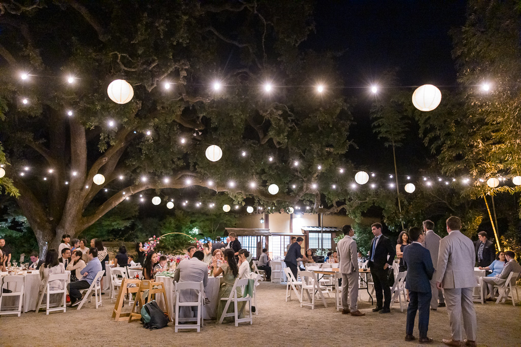 nighttime photo of outdoor reception at Hakone Gardens with string lights and lanterns
