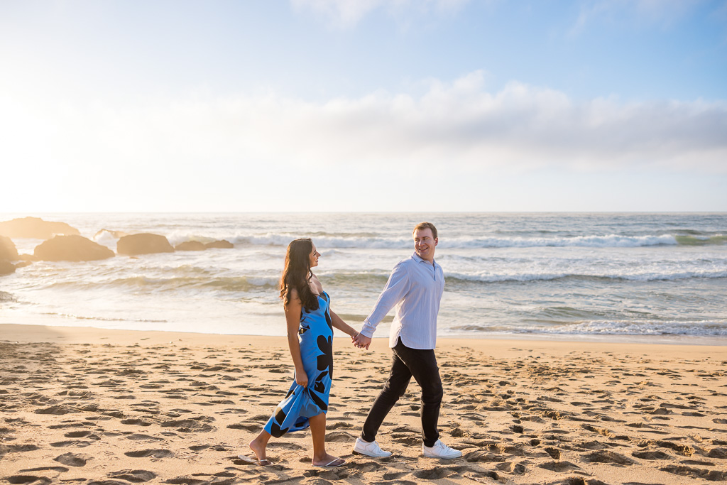 engagement photos walking along the beach at sunset