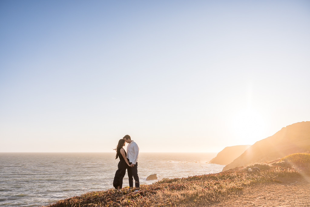 golden hour engagement photos on a cliff over the ocean