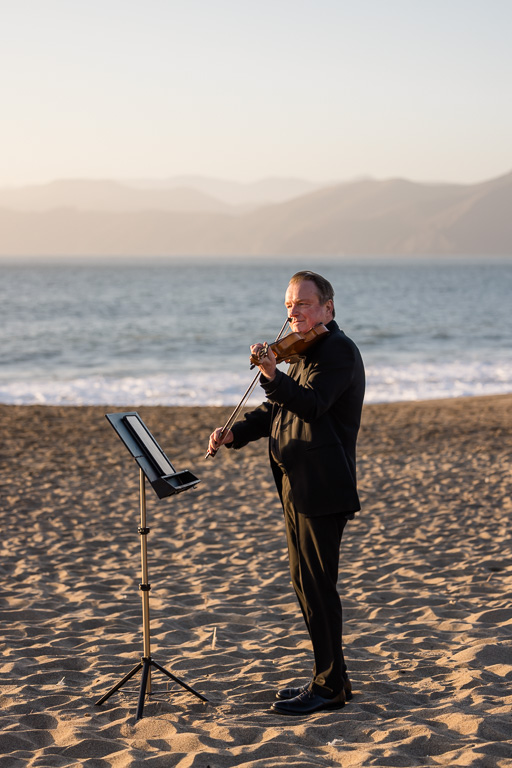 Wes the violinist playing for a beach proposal