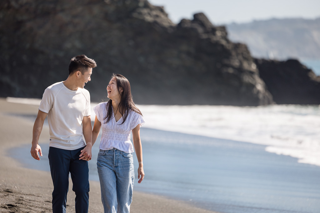 couple walking along Black Sands Beach