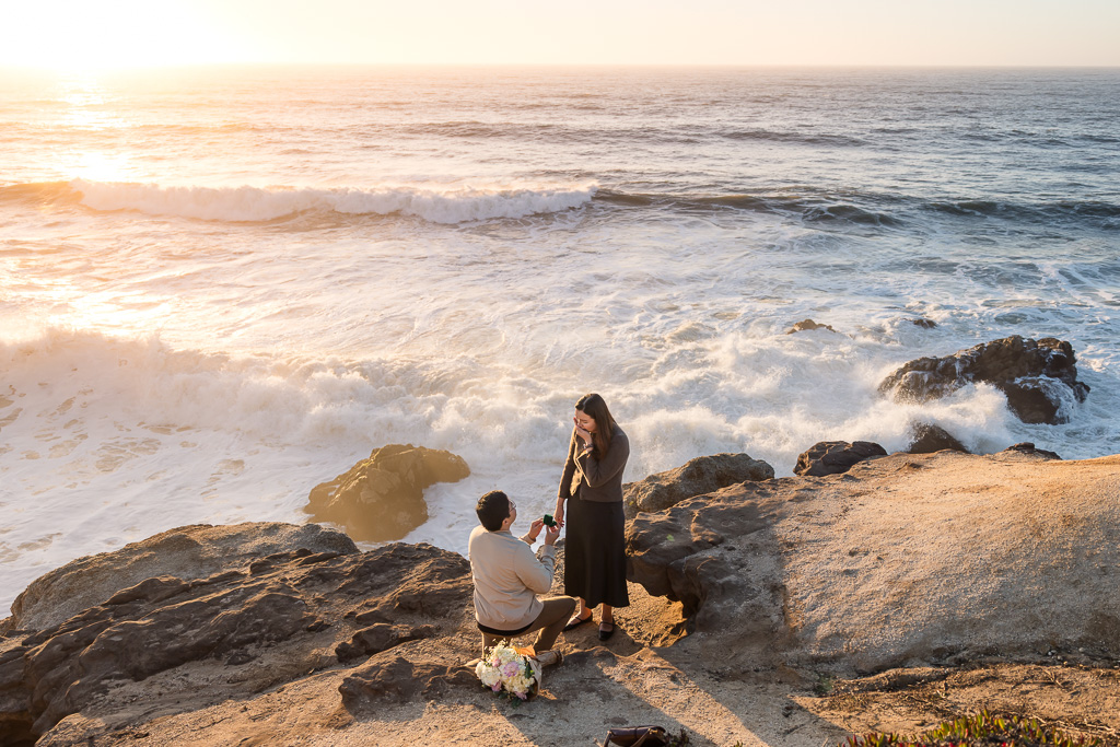 surprise proposal above crashing ocean waves against cliff edge