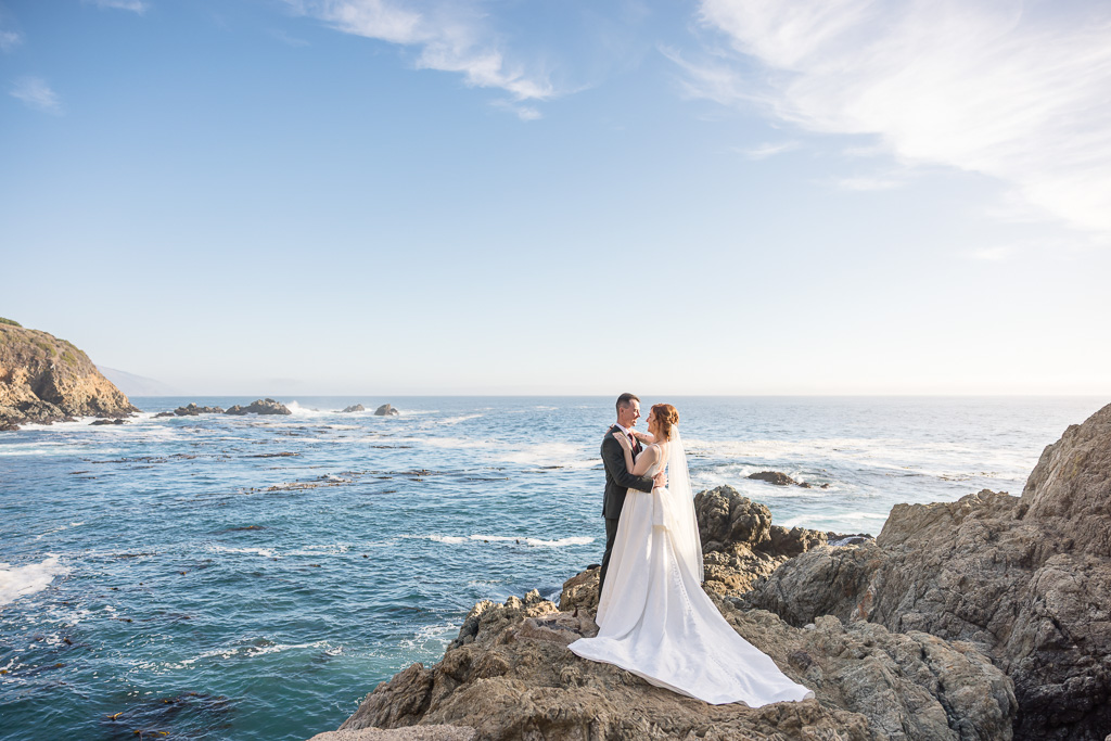 Big Sur Partington Cove elopement couple walking along dramatic coastal cliffs ocean backdrop
