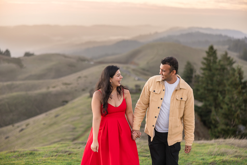 engagement photos on a green grassy hill
