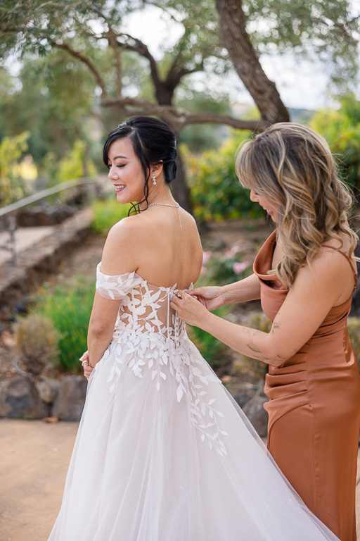 sister of the bride helping with dress
