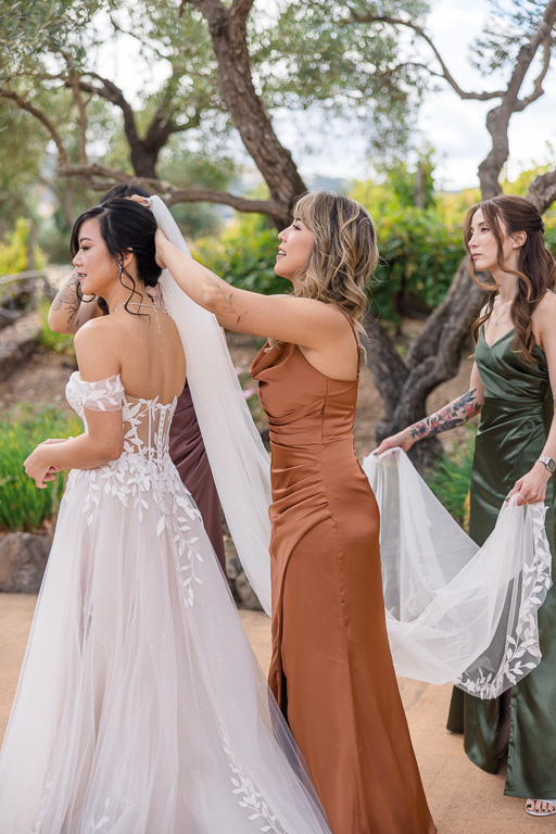 bridesmaids helping bride with her veil