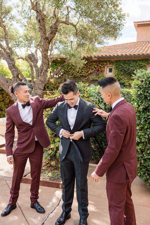 groomsmen helping the groom with getting ready
