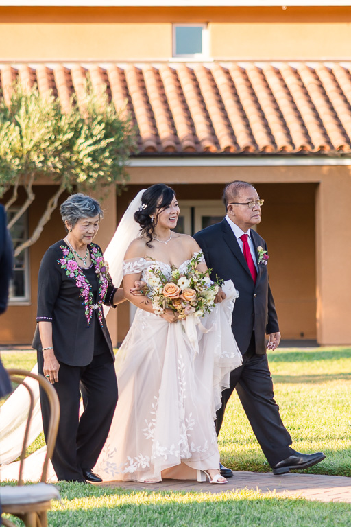 bride and parents in the aisle