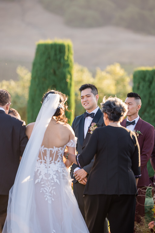 groom looking at the bride as she walks towards him at the end of the aisle