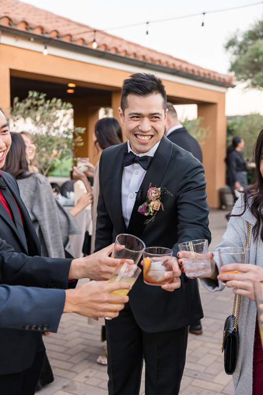 groom enjoying a drink with friends at cocktail hour