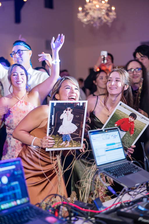 some friends holding up prints of the bride and groom as kids