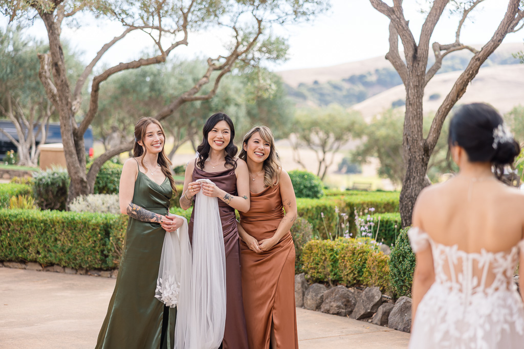 a cute moment where the bridesmaids are looking sweetly at their bride