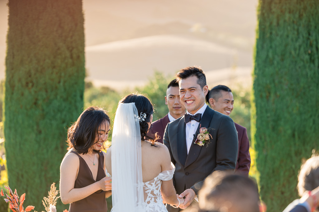 groom smiling at his bride during the ceremony