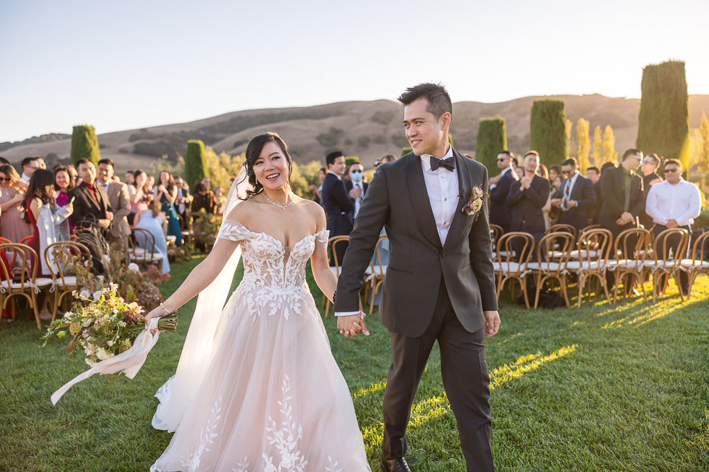 candid shot of bride and groom walking away from the outdoor ceremony at Viansa