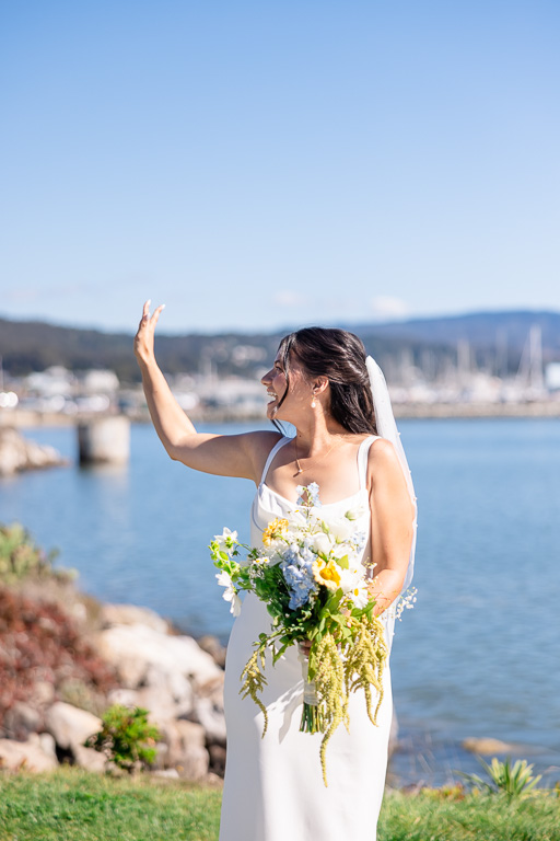 bride waving at her bridesmaids just before first look