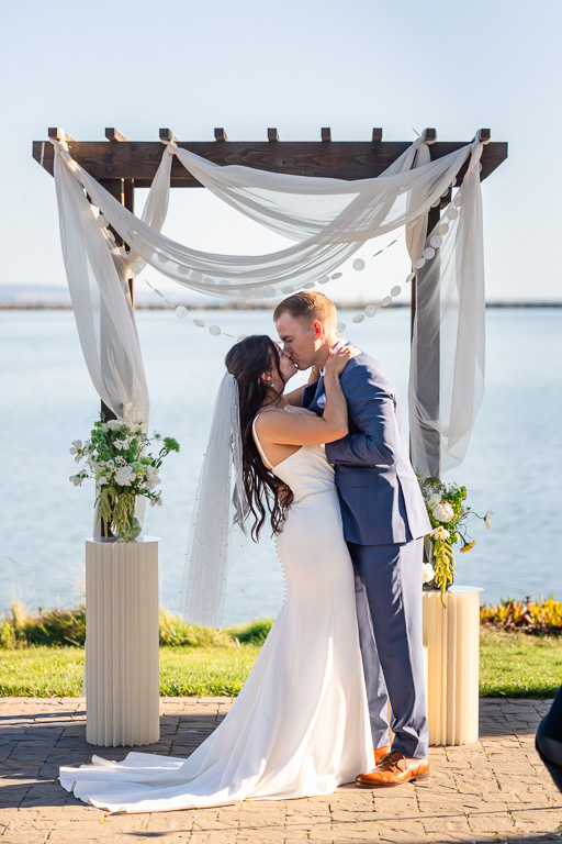 first kiss at the wedding arbor at Mavericks House